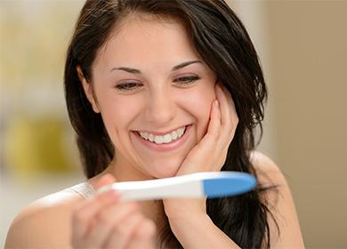Lächelndes Mädchen, das einen Schwangerschaftstest betrachtet