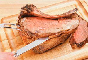 Gekochtes Schweinefleisch stieg aus dem langsamen Kocher und schnitt mit einem Messer
