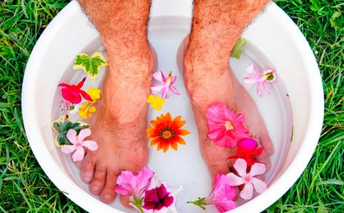 Männerbeine in einem Becken mit Wasser und Blumen