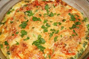 Ang banayad na omelette ay binuburan ng berdeng mga sibuyas
