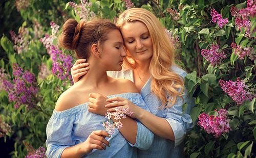 Anna und Vasilisa auf dem Hintergrund der lila Blüten