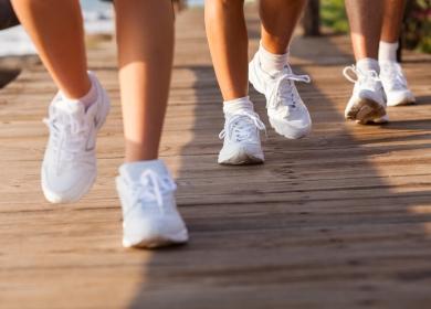 Λευκά αθλητικά παπούτσια στα πόδια των ανθρώπων που τρέχουν