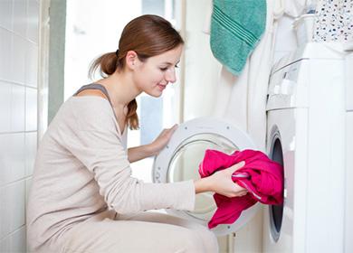 Frau setzt rote Strickjacke in die Waschmaschine ein
