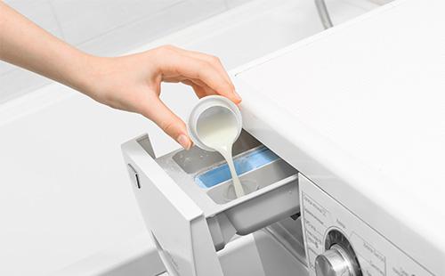 Waschmittel in eine Waschmaschine gegossen