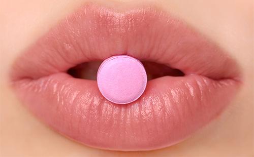 Rosa Tablette auf den Lippen