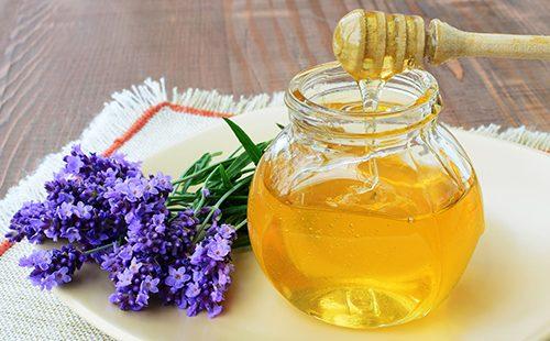 Jar ng honey at isang sprig ng mabangong lavender