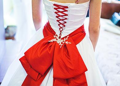 Rote Schleife an einem weißen Kleid