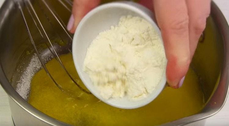 Magdagdag ng vanilla sugar at harina sa mga yolks.