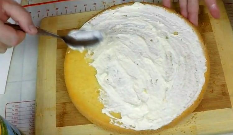 Lubricate ang unang cake na may maraming cream.