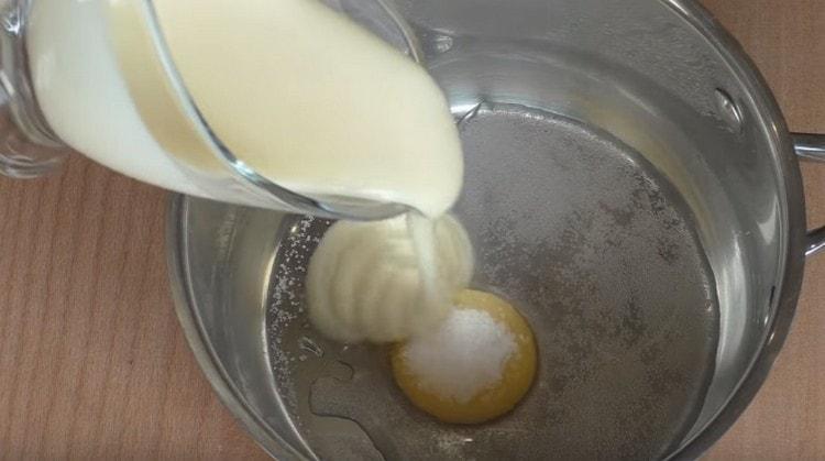Magdagdag ng vanilla sugar, condensed milk at tubig sa pula ng itlog.