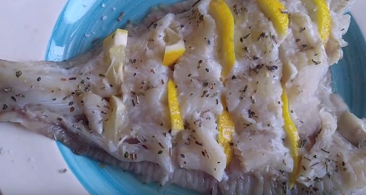 Ipasok ang mga hiwa ng lemon sa mga incision na ginawa sa flounder.