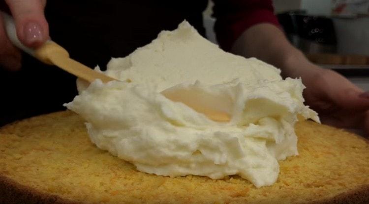 Lubricate ang unang cake na may isang copious layer ng cream.