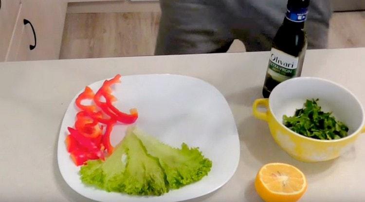 Salat und Pfeffer auf eine Servierplatte geben.