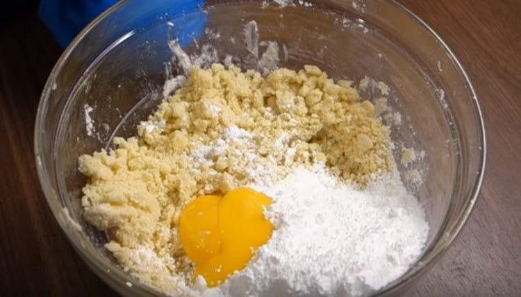 Idagdag ang mga yolks at pulbos na asukal sa mga nagreresultang mumo.