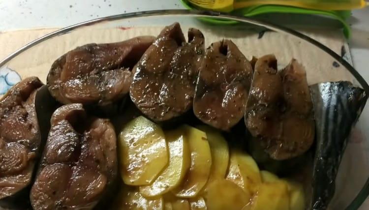 Ipinakalat namin ang mga piraso ng tuna at patatas sa isang baking dish, na dati nang lubricated ang ilalim nito na may marinade.