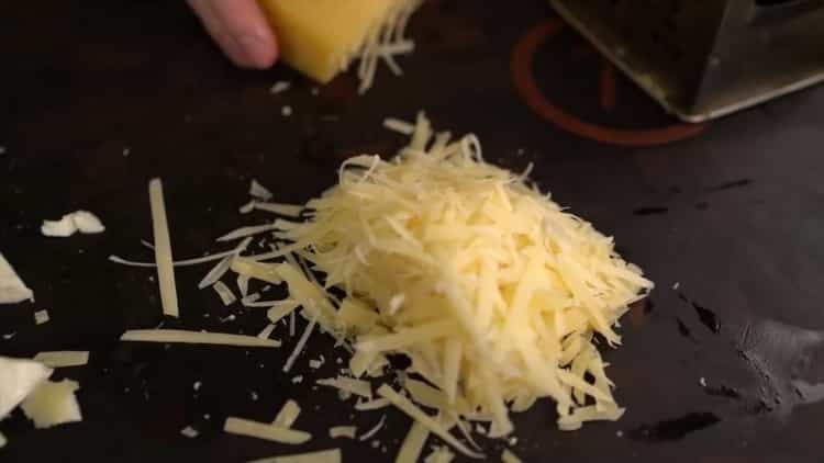 Reiben Sie Käse, um klassische Pizza zu machen