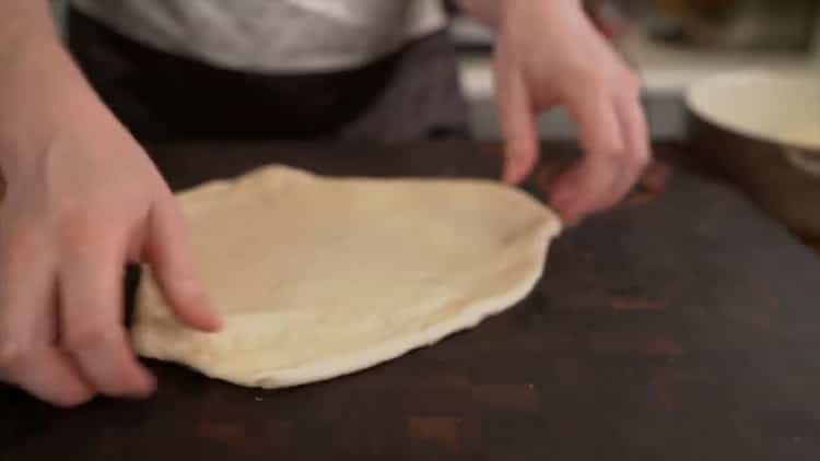 Rollen Sie den Teig, um eine klassische Pizza zu machen