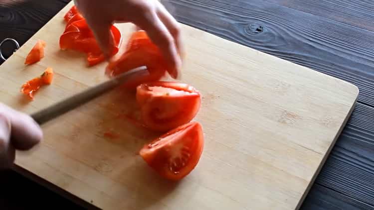 Hacken Sie die Tomate, um Pizza mit Hühnchen zu machen
