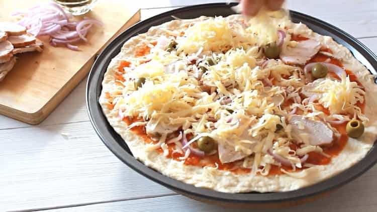 Füllen Sie den Käse mit der Füllung, um Pizza mit Hühnchen zuzubereiten