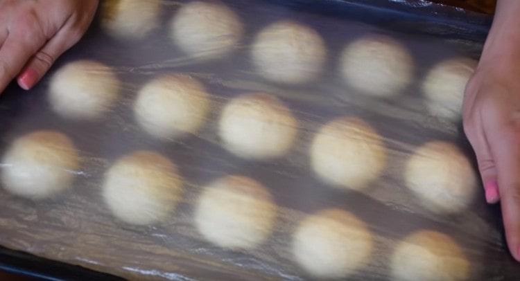 Sinasaklaw namin ang mga buns sa isang baking sheet na may isang pelikula at hayaan silang lumapit nang kaunti.