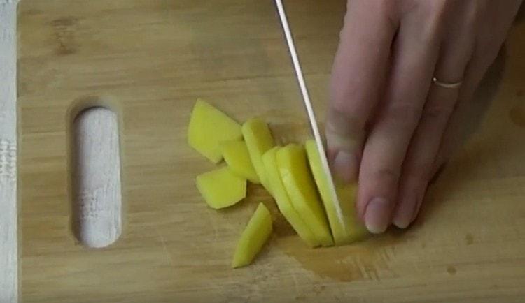 Peel at i-chop ang mga patatas.