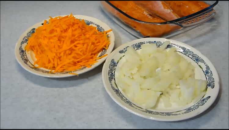 Нарежете лука и морковите за приготвяне на розова сьомга