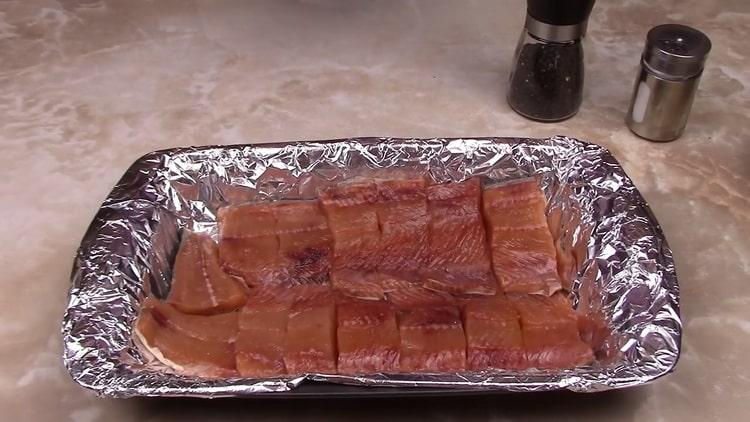 Upang maghanda ng pink salmon sa isang creamy sauce, ilagay ang isda sa isang baking sheet