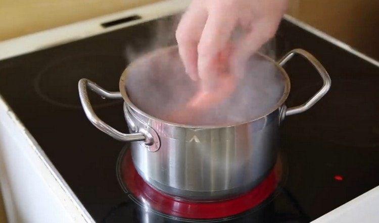 Wir legen Würstchen in kochendes Wasser.