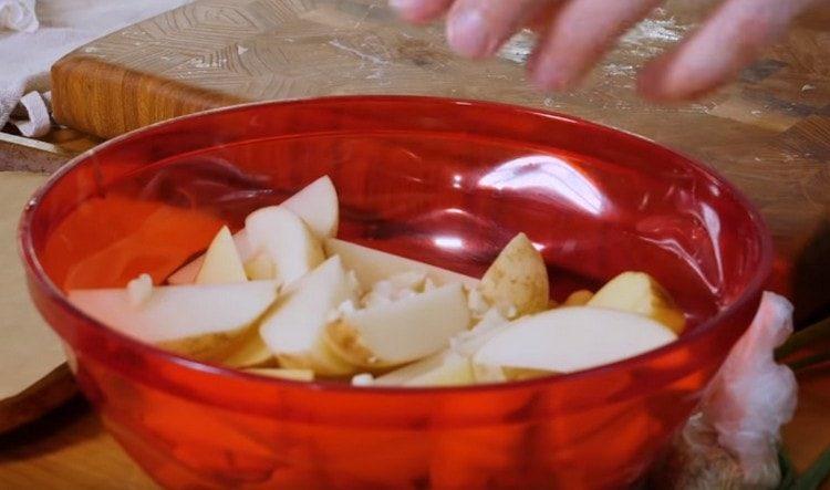 نضع البطاطس في وعاء ، نضيف الثوم المفروم.