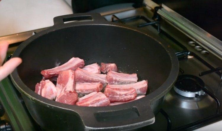 في الزيت الحار ، اغمس أضلاع لحم الخنزير.