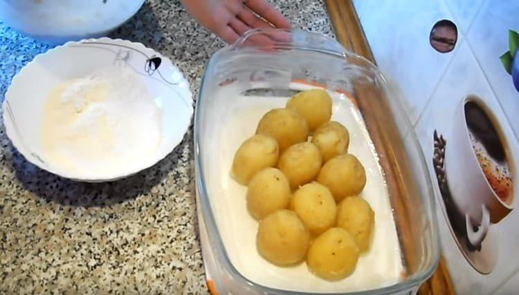 Ilagay ang pinakuluang patatas sa baking dish.